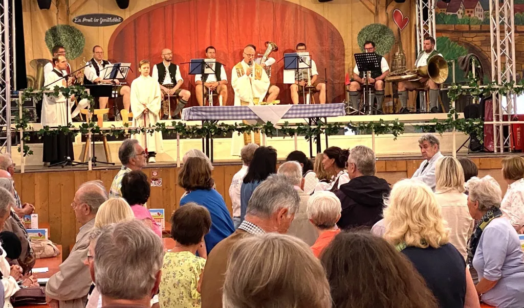 Dultgottesdienst im Festzelt: Priester am Altar, Musiker und Gemeinde in den Bankreihen