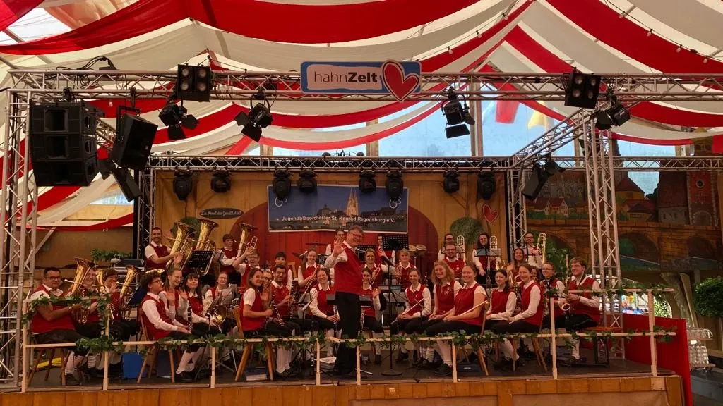 Jugendblasorchester St. Konrad in roten Hemden auf der Bühne im Hahnzelt
