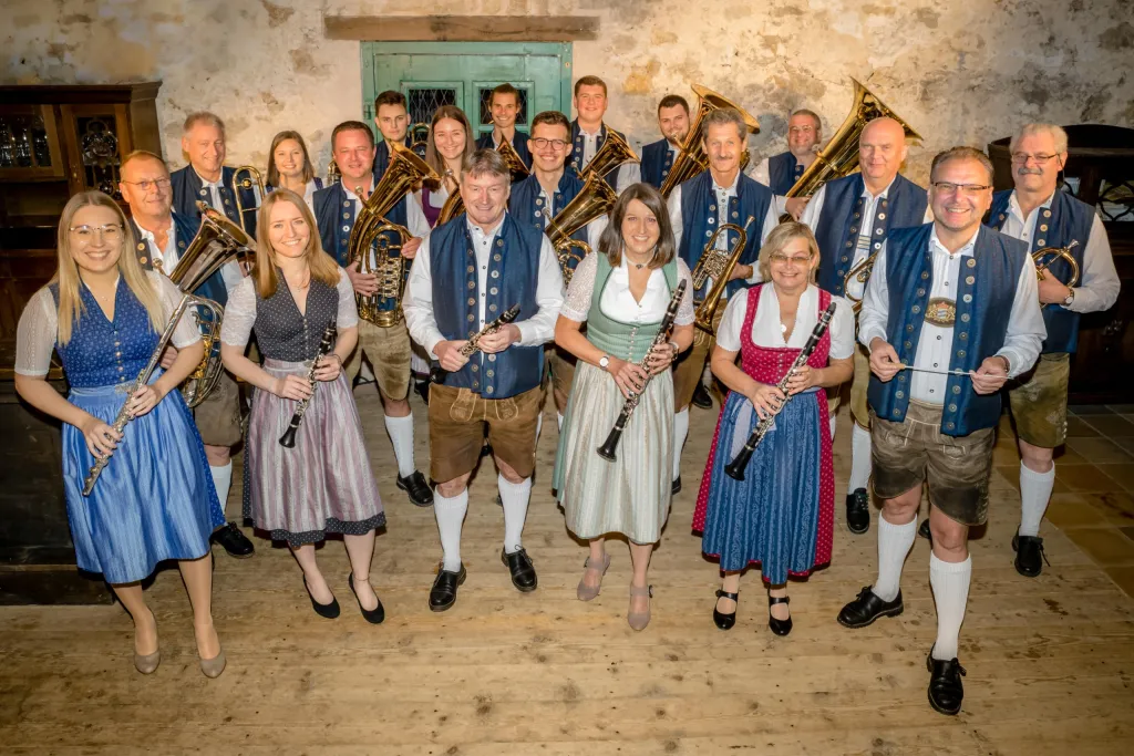 Deuerlinger Blasmusik in blauen Trachtenwesten und Dirndln mit Blechblasinstrumenten