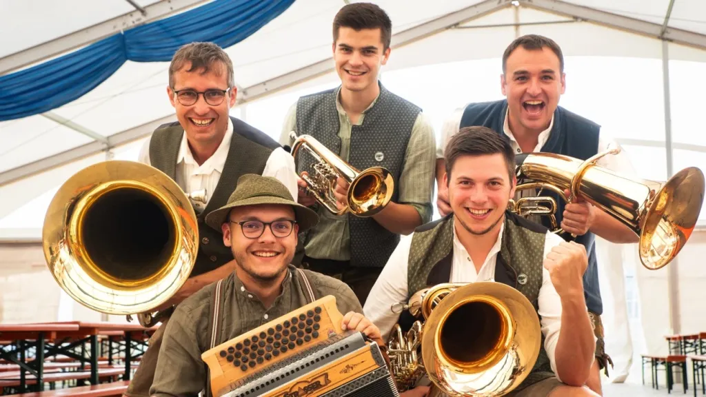 Fünf junge Musiker der Bockl-Blech mit Tuben, Trompete und Akkordeon im Festzelt