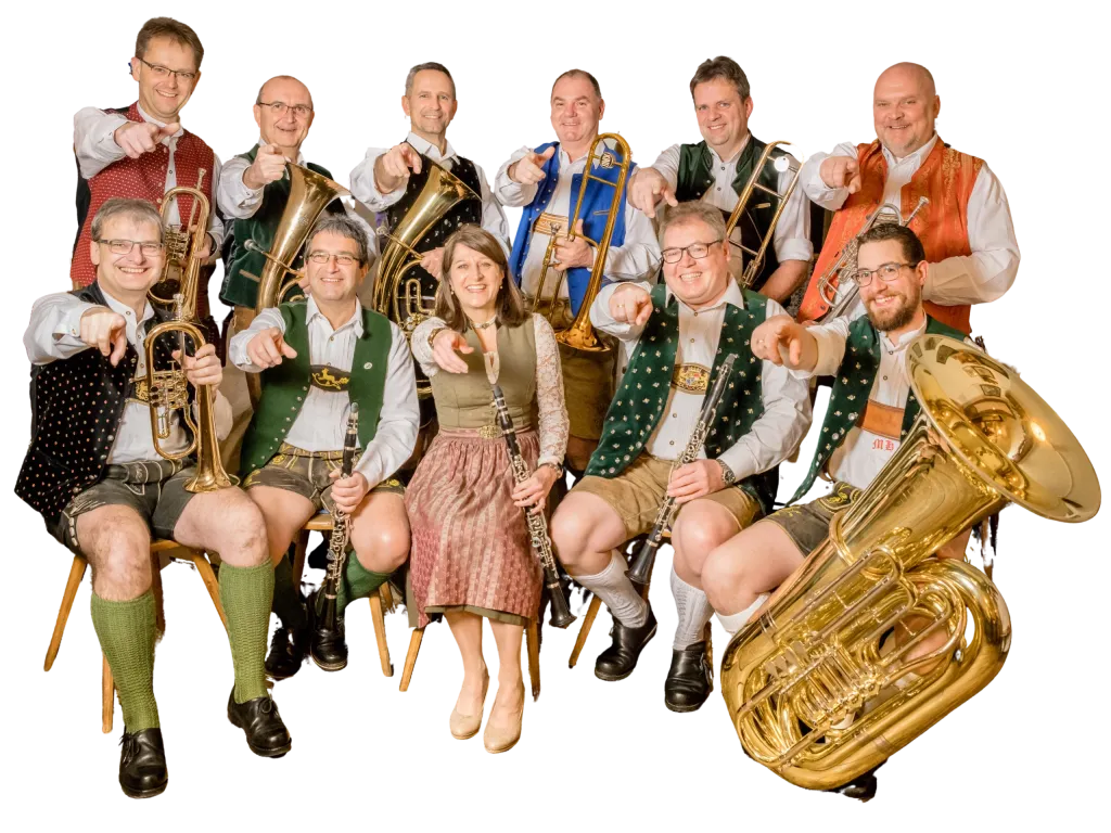 Die Oberlinger Musikanten: elf Musikerinnen und Musiker in Tracht mit Blasinstrumenten, freigestellt vor schwarzem Hintergrund