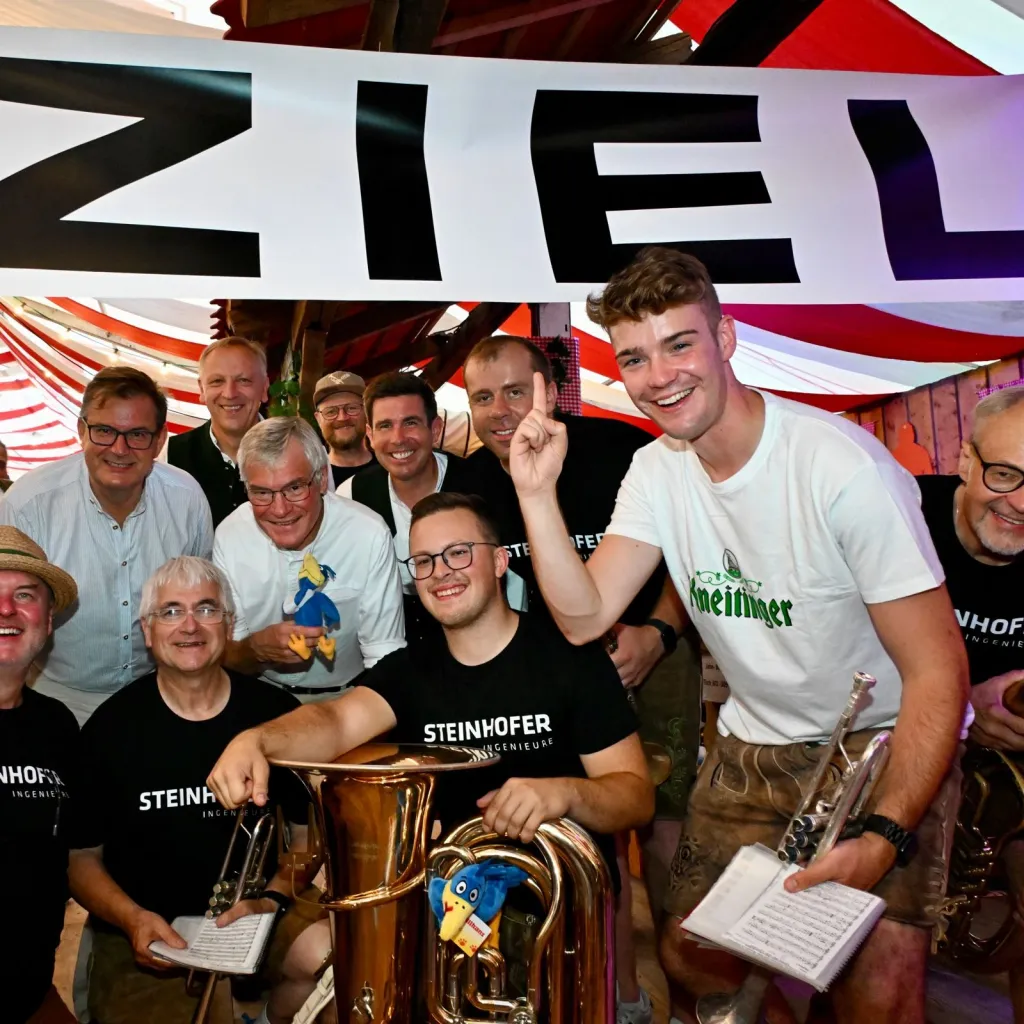 Gruppe von Männern mit Tuba und Trompete unter "ZIEL"-Banner im Hahnzelt