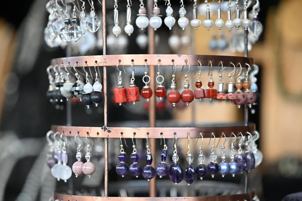 Drehständer mit handgefertigtem Perlenschmuck und Ohrringen am Marktstand