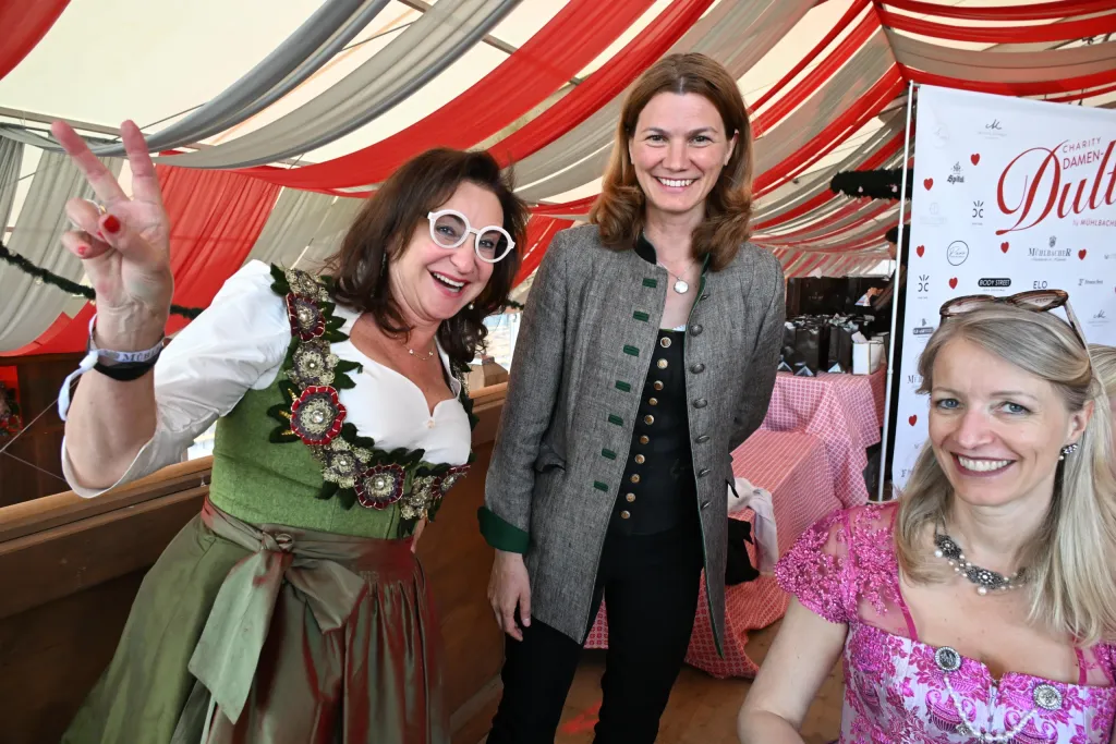 Drei Frauen in Dirndl und Janker lachen beim Damendult-Treffen im Festzelt