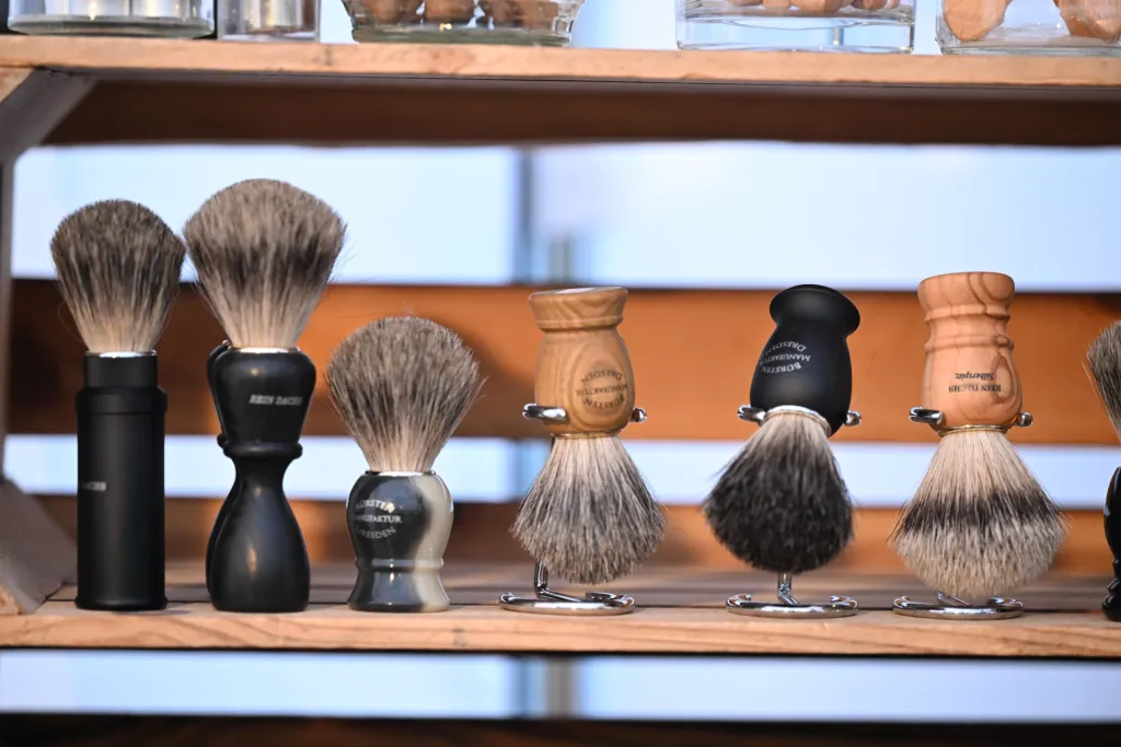 Auswahl handgefertigter Rasierpinsel mit Holz- und Hornriffen auf einem Verkaufsregal