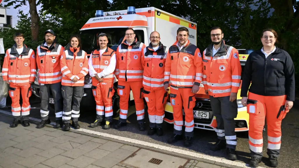 Gruppenfoto der Sanitäter des Bayerischen Roten Kreuzes vor Rettungswagen