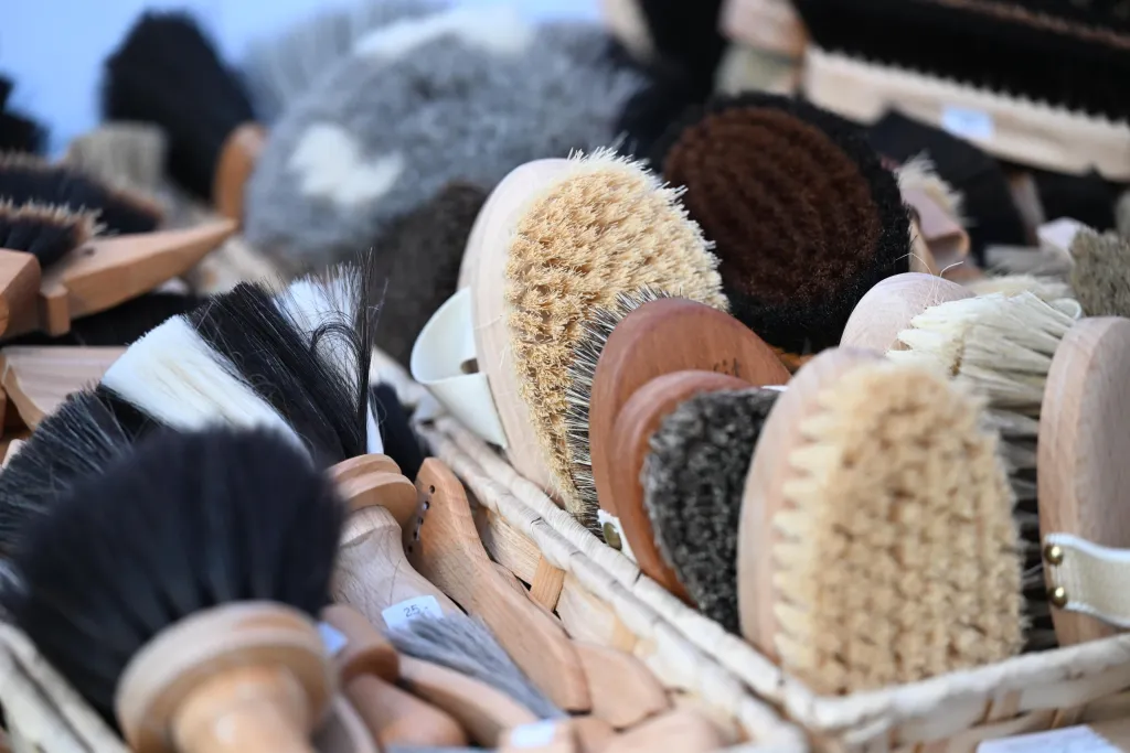Auswahl handgefertigter Holzbürsten und Naturhaarbürsten in Körben am Marktstand