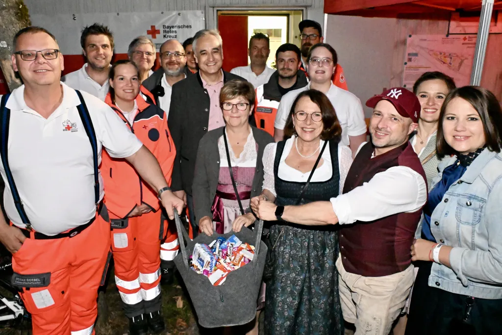 Helfer vom Bayerischen Roten Kreuz und Gäste in Tracht im Sanitätszelt