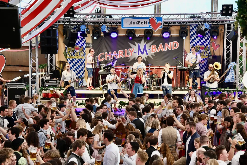 Charly M Band auf der Bühne im Hahnzelt, Publikum tanzt vor der Bühne
