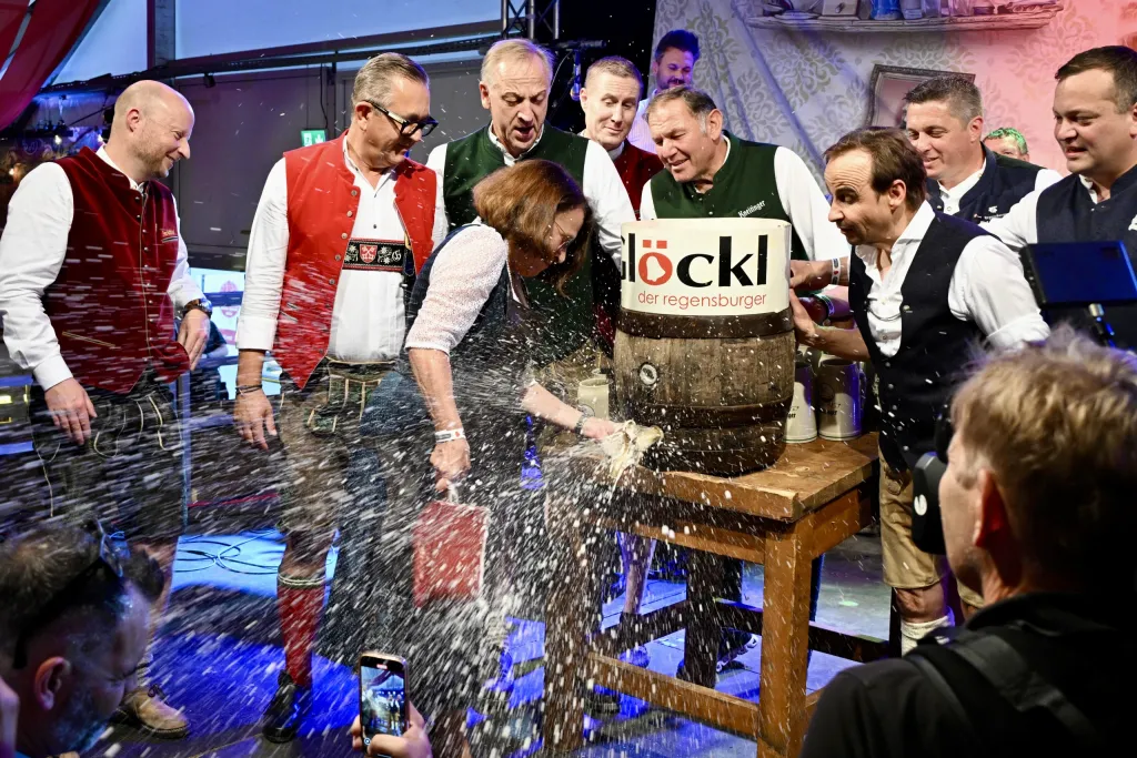 Festwirt schlägt Bieranstich mit Holzhammer auf Glöckl-Holzfass beim Anzapfen