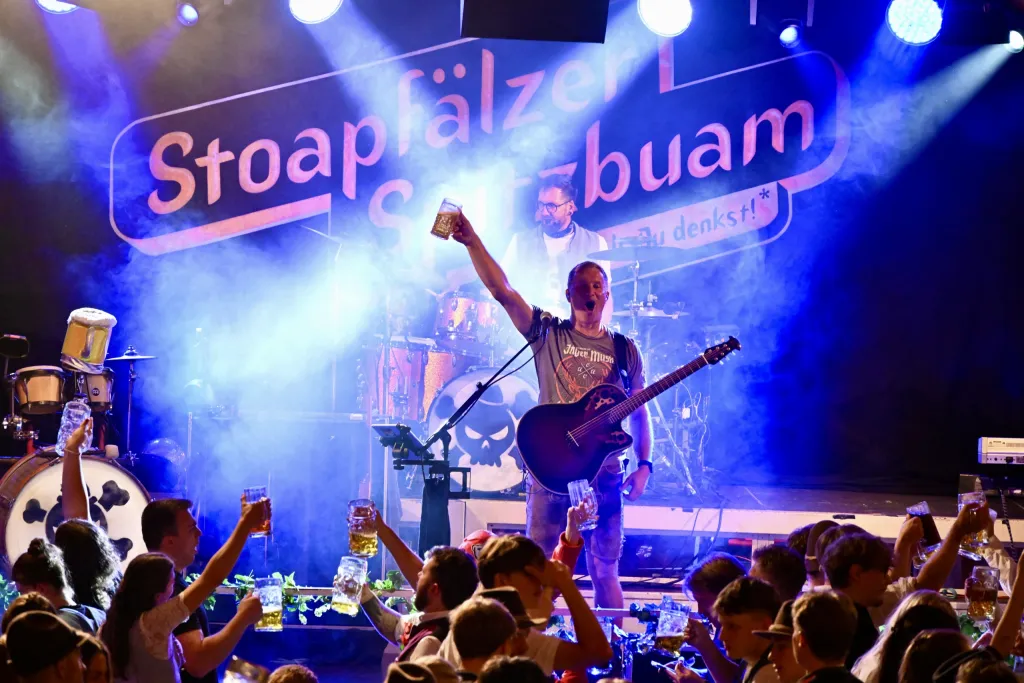 Konzert der Band Stoapfälzer Saubuam mit Gitarrist und jubelnden Fans vor der Bühne