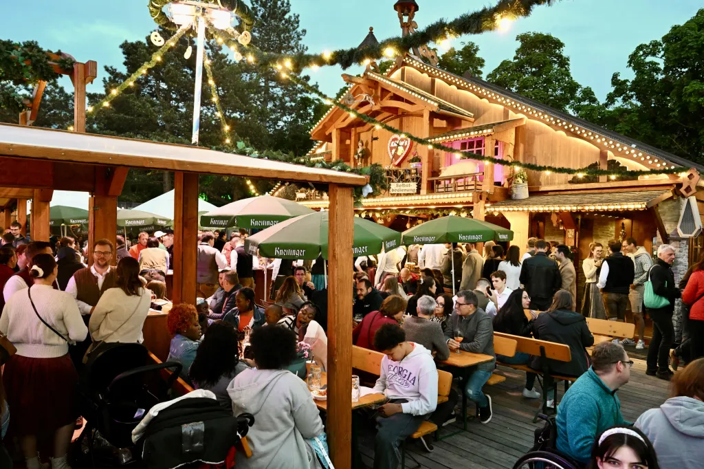 Holzhütte mit Lichterketten und Außenbestuhlung im Biergartenbereich der Dult