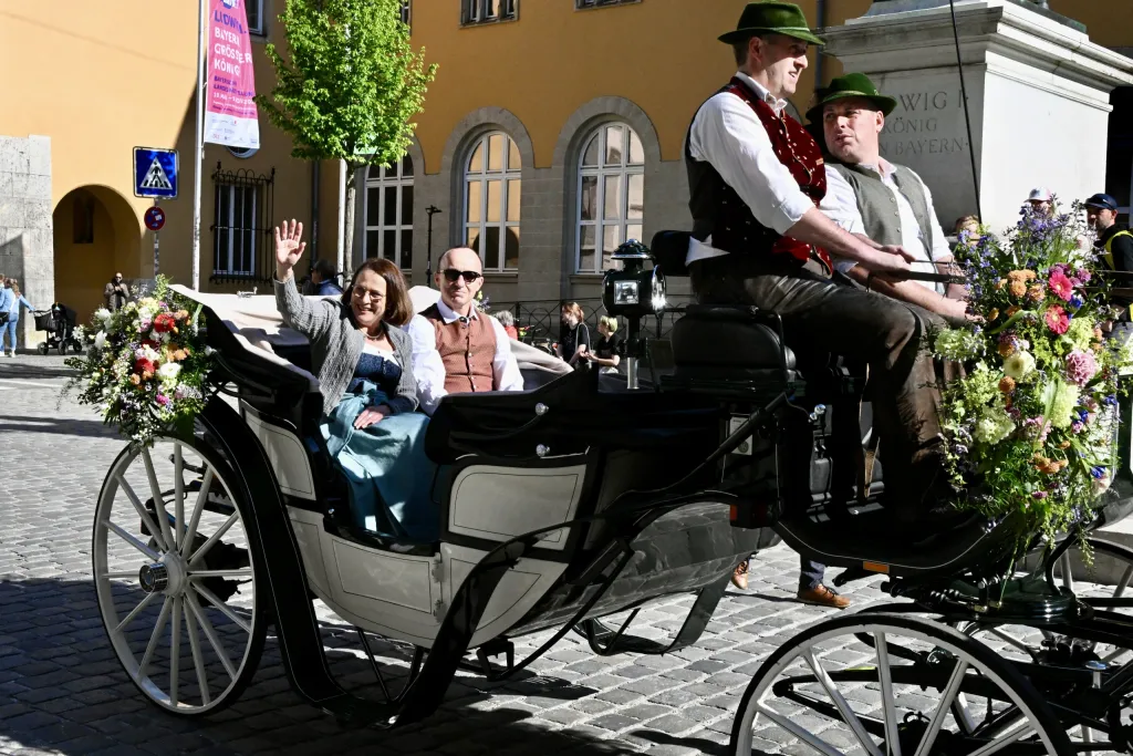 Trachtenträger in geschmückter Pferdekutsche beim Festumzug durch die Innenstadt
