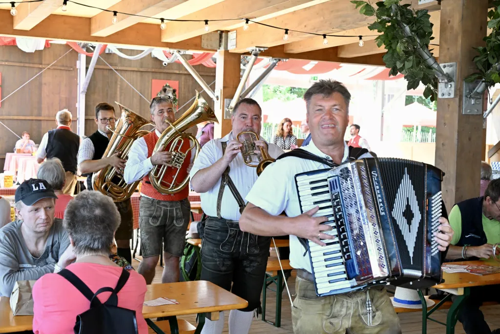 Blaskapelle mit Akkordeon, Tuba und Tenorhorn in Lederhose musiziert im Festzelt