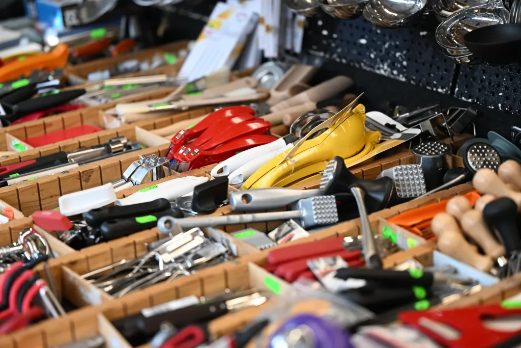 Auslage mit bunten Küchenhelfern, Sparschälern und Werkzeugen am Marktstand
