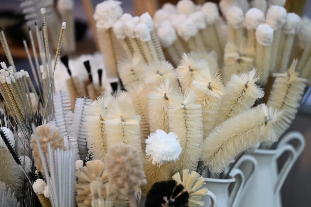 Verschiedene Flaschenbürsten aus hellem Naturhaar im Marktstand aufgereiht