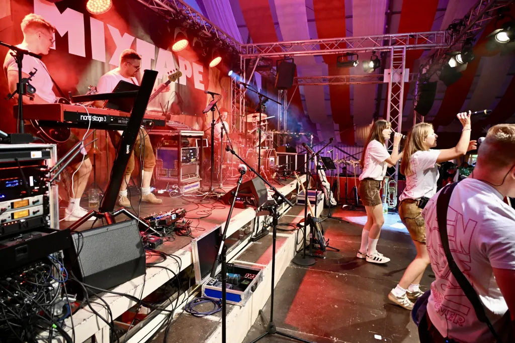 Band Mixtape auf der Bühne im Hahn Zelt, Sängerinnen und Keyboarder im Scheinwerferlicht