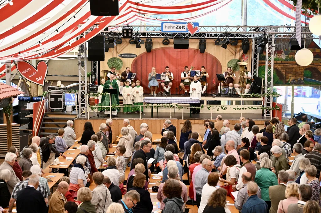 Volles Festzelt mit Publikum auf Bierbänken vor der Bühne der Veranstaltungsreihe Kultzelt